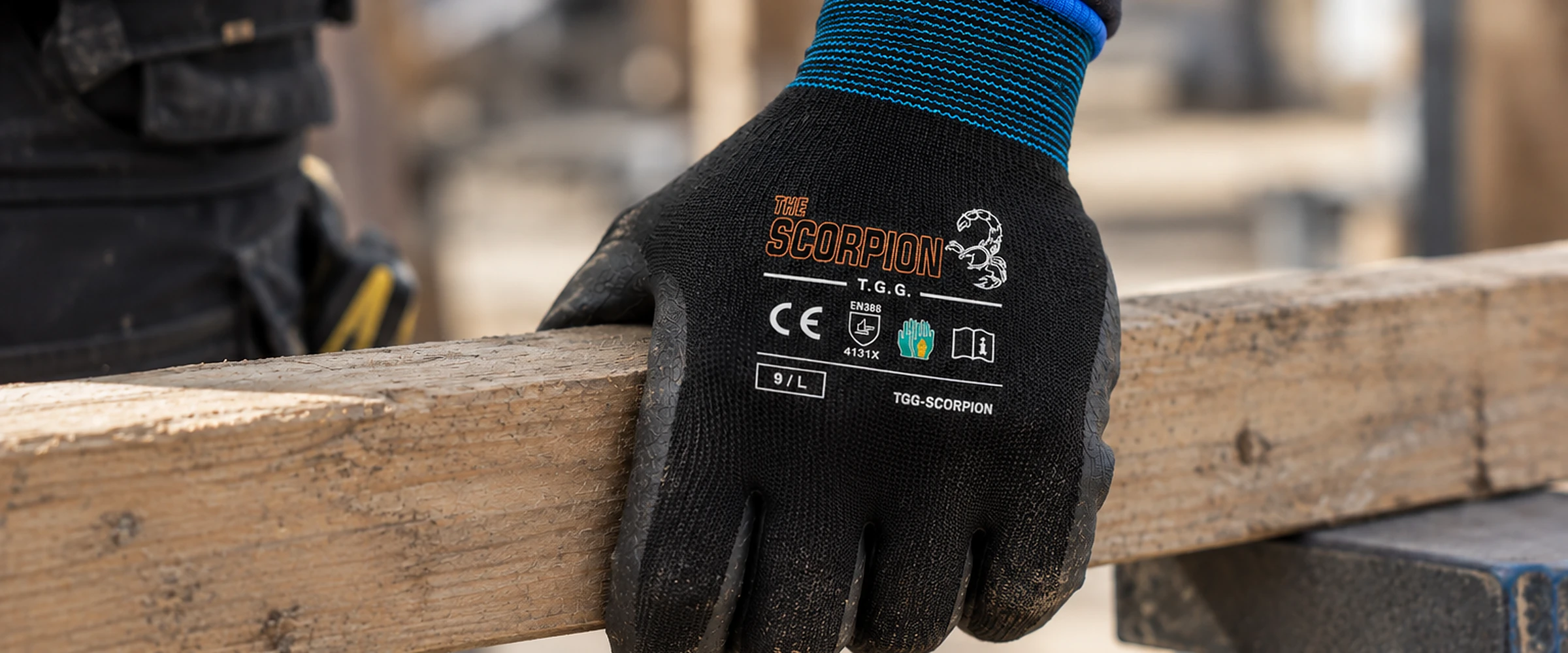 Gloved hand in a TGG Scorpion work glove carrying timber on site